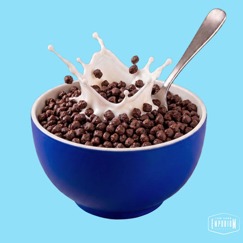 Bowl of chocolate protein cereal nuggets with a milk splash
